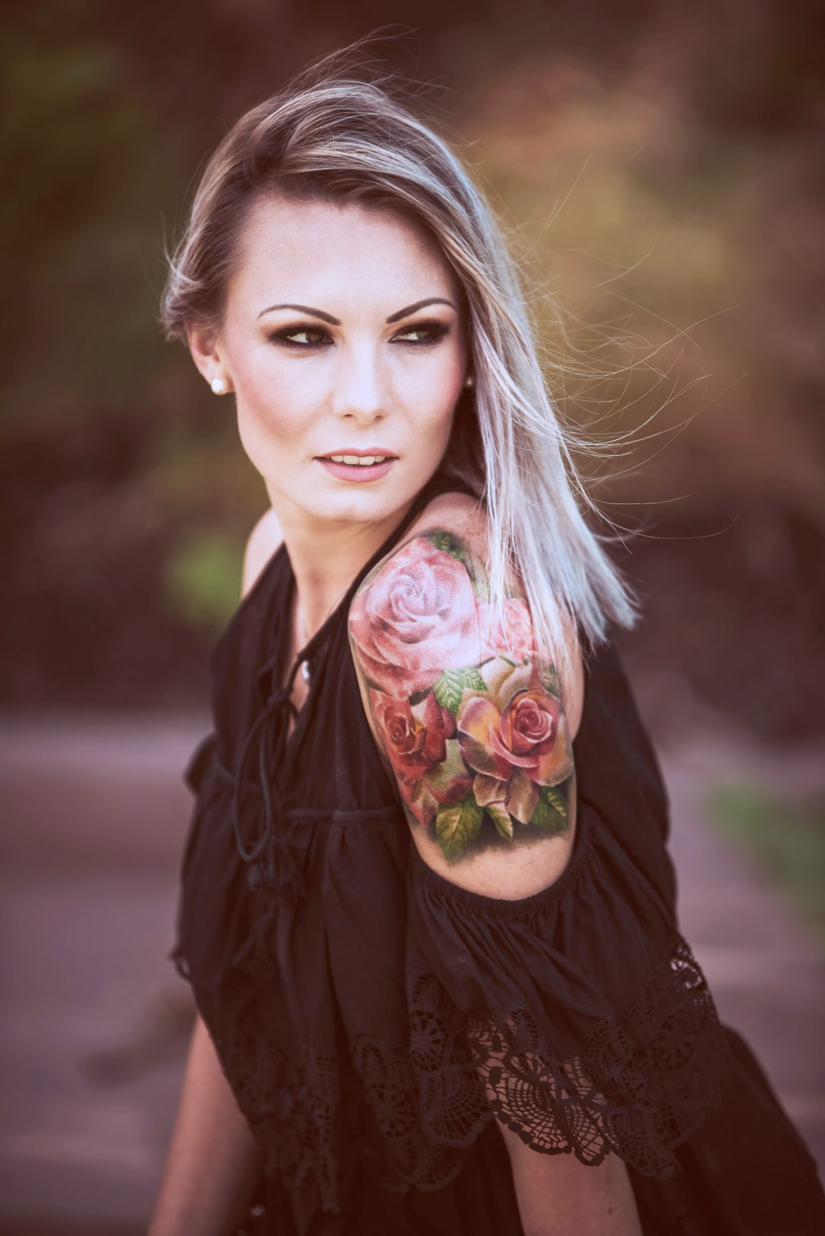 dziewczyna z tatuażem na ręce patrząca w dal