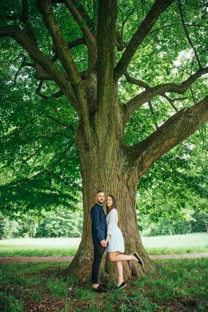 chłopak i dziewczyna stojący pod dużym drzewem